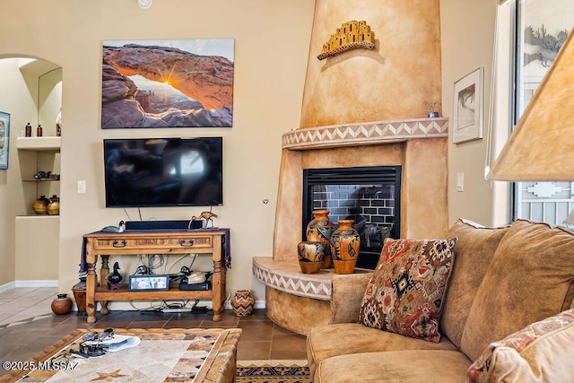 living area featuring tile patterned flooring, a fireplace, and baseboards