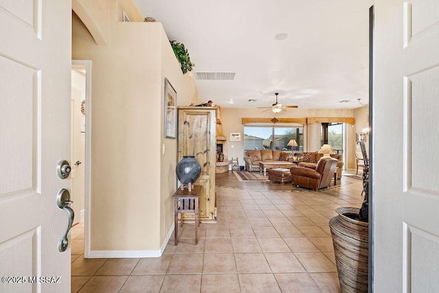 foyer with baseboards, visible vents, a ceiling fan, and light tile patterned flooring