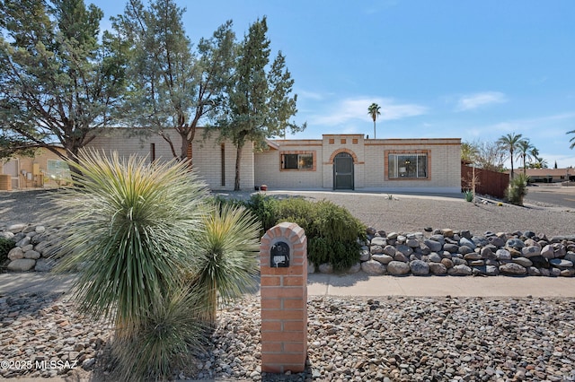 view of front of property featuring brick siding and fence