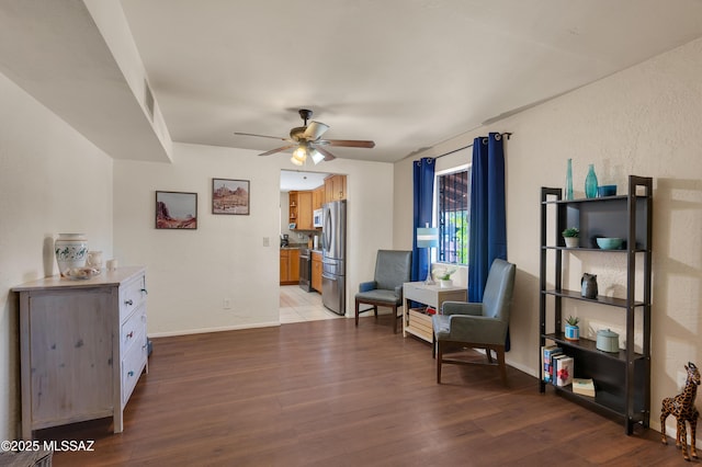 sitting room featuring ceiling fan, wood finished floors, and baseboards