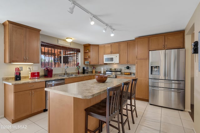 kitchen featuring appliances with stainless steel finishes, brown cabinetry, light countertops, and a sink