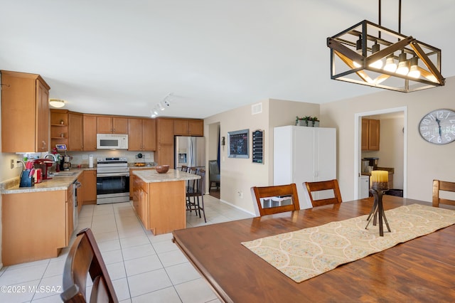 kitchen with a sink, visible vents, stainless steel appliances, and light countertops