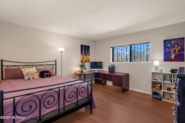 bedroom featuring baseboards and wood finished floors