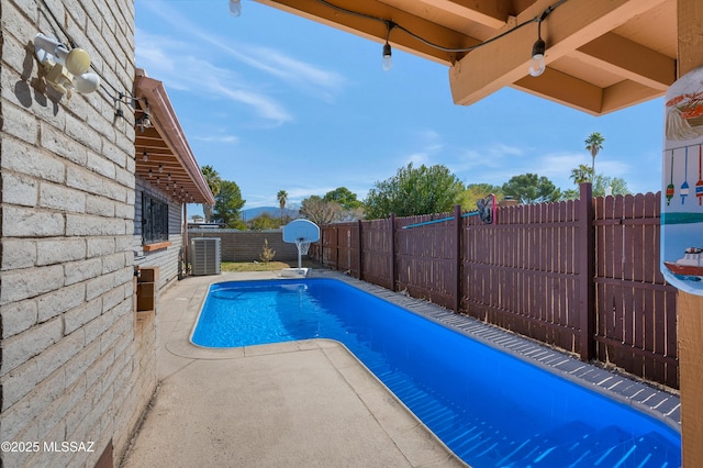 view of pool with central air condition unit, a fenced backyard, a fenced in pool, and a patio