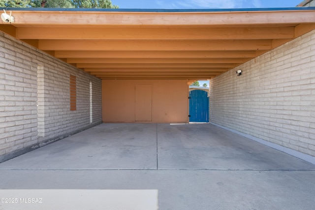 view of vehicle parking featuring a gate and a carport