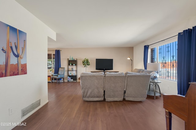 living area featuring visible vents and wood finished floors