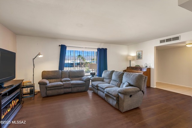 living area with visible vents and wood finished floors