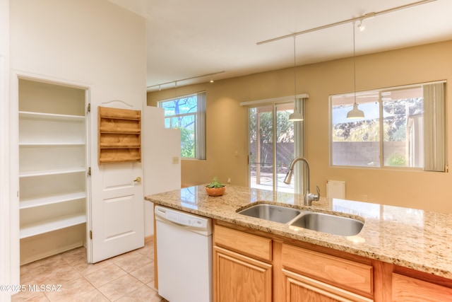 kitchen featuring a sink, decorative light fixtures, white dishwasher, light tile patterned floors, and light stone countertops