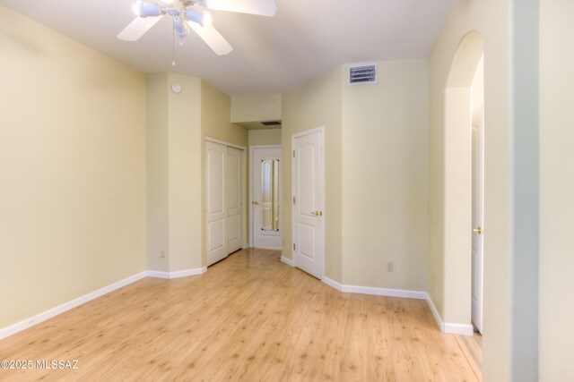 unfurnished bedroom featuring light wood finished floors, visible vents, baseboards, a closet, and a ceiling fan