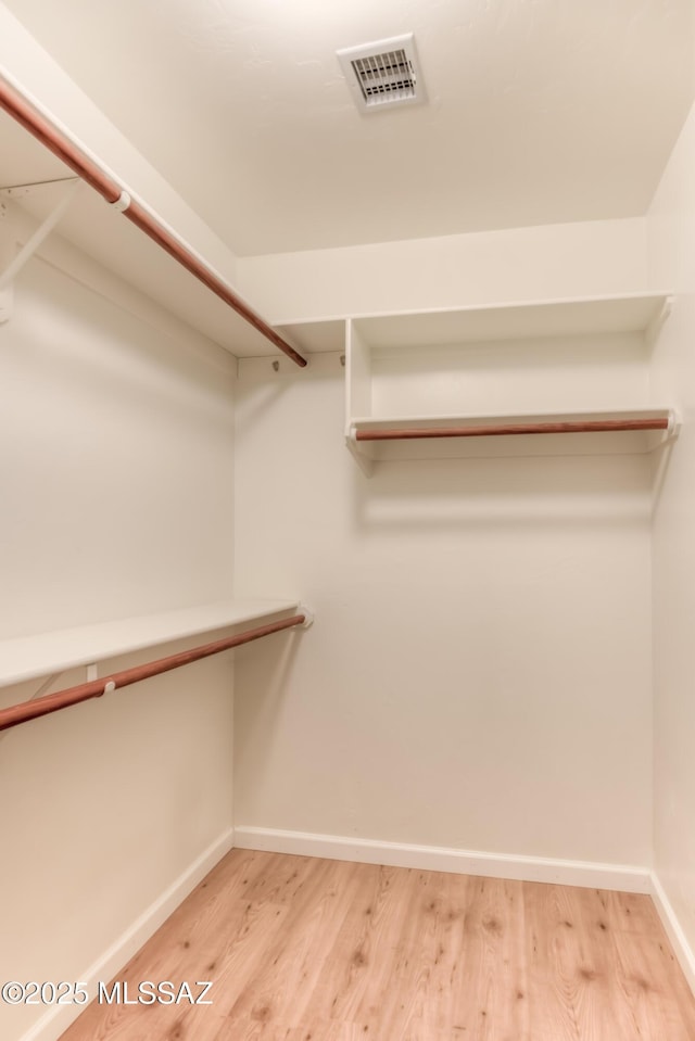 walk in closet featuring wood finished floors and visible vents