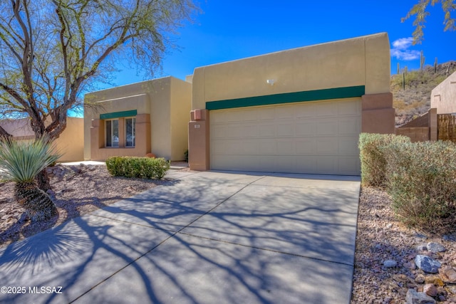 adobe home featuring concrete driveway, a garage, and stucco siding