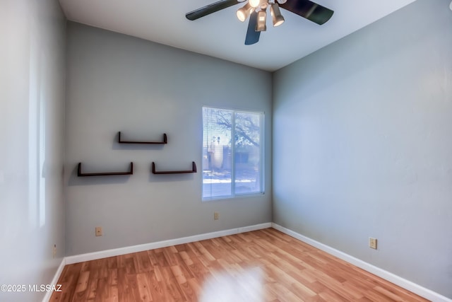 empty room with ceiling fan, baseboards, and wood finished floors