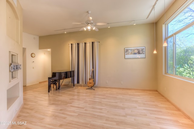 unfurnished room featuring light wood-style floors, a healthy amount of sunlight, and ceiling fan