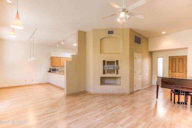 living area with visible vents, light wood-style flooring, and baseboards