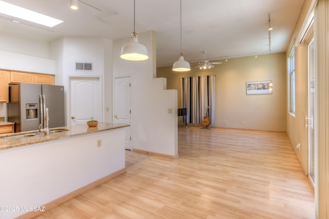 kitchen featuring light brown cabinets, visible vents, stainless steel fridge with ice dispenser, rail lighting, and light wood-style floors