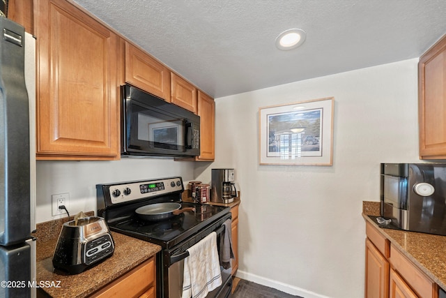 101 S Players Club Dr Unit 11202, Tucson, AZ 85745 - kitchen with dark stone counters, appliances with stainless steel finishes, a textured ceiling, and baseboards
