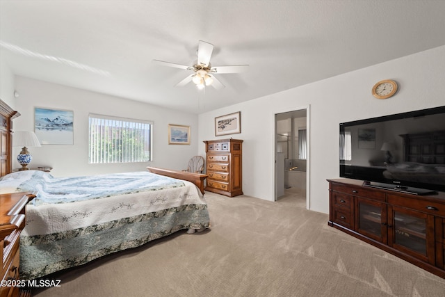 bedroom featuring connected bathroom, light colored carpet, and a ceiling fan