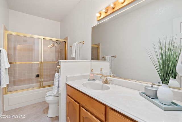 bathroom featuring vanity, tile patterned floors, toilet, and combined bath / shower with glass door