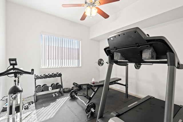 exercise area with a ceiling fan and baseboards