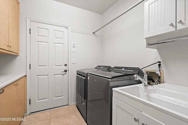 washroom with washer and clothes dryer, light tile patterned floors, cabinet space, and a sink