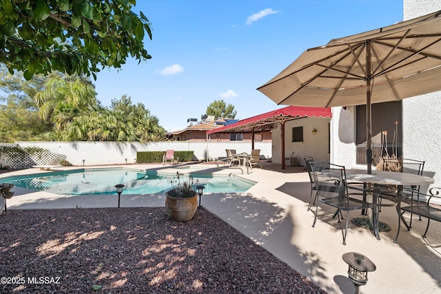 view of swimming pool featuring outdoor dining space, a fenced in pool, fence, a diving board, and a patio area