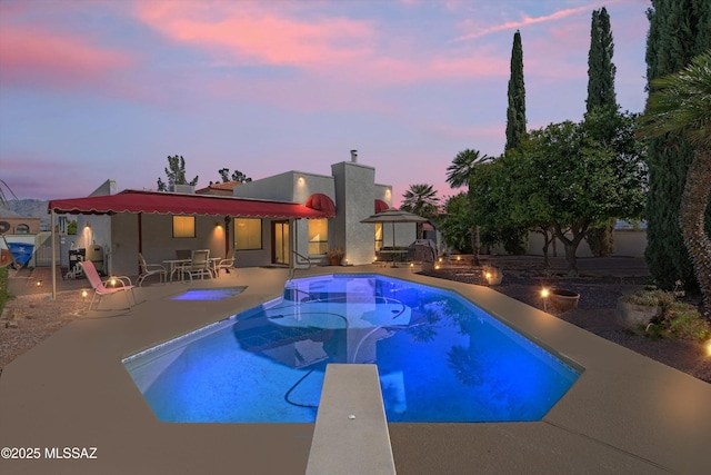 pool with a patio and a diving board