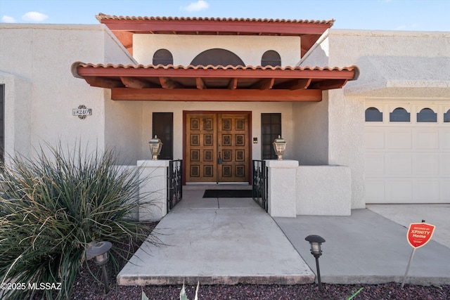 property entrance with a garage and stucco siding