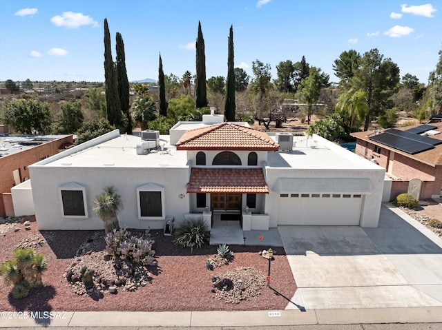 mediterranean / spanish home featuring a tiled roof, an attached garage, driveway, and stucco siding