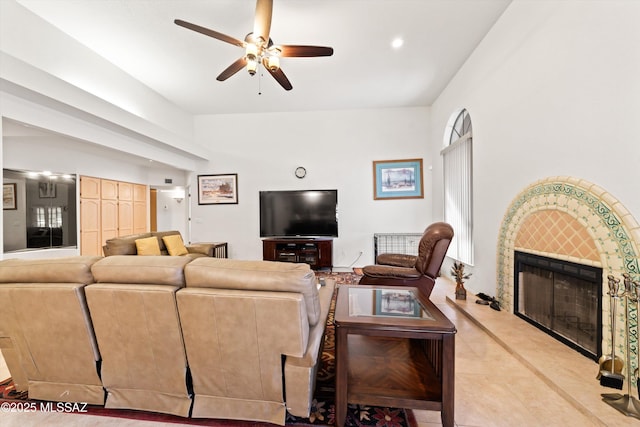 living room featuring recessed lighting, light tile patterned flooring, a fireplace with raised hearth, and a ceiling fan