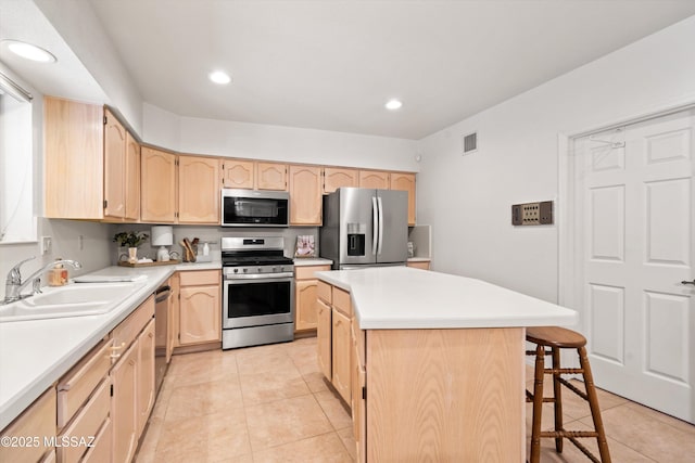 kitchen featuring light brown cabinetry, visible vents, appliances with stainless steel finishes, and a sink