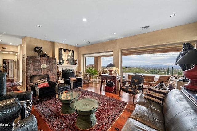 living room with recessed lighting, visible vents, a fireplace, and wood finished floors