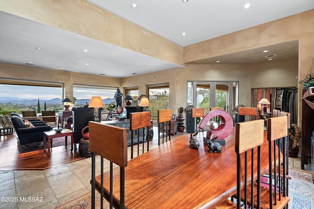 dining room featuring a wealth of natural light, stone tile flooring, french doors, and recessed lighting