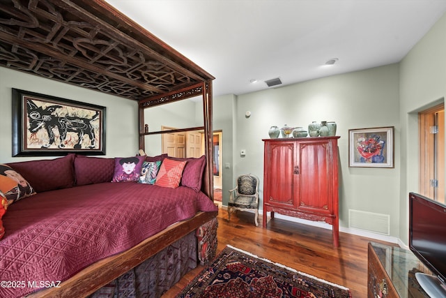 bedroom featuring dark wood-style flooring, visible vents, and baseboards