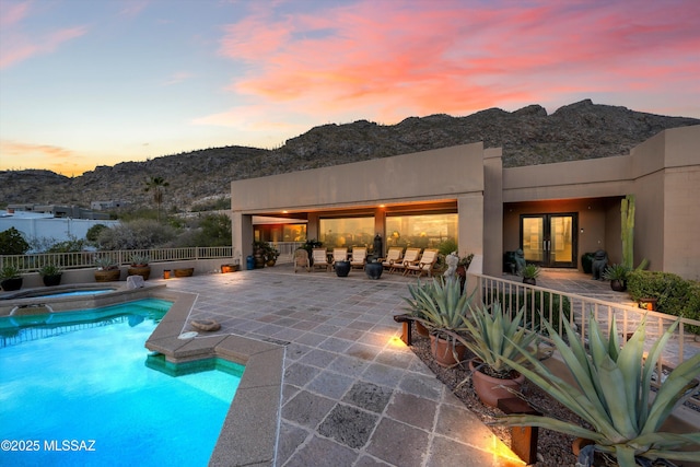 view of swimming pool with a fenced in pool, an in ground hot tub, fence, french doors, and a patio area