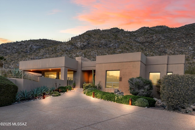 pueblo-style home featuring a mountain view and stucco siding