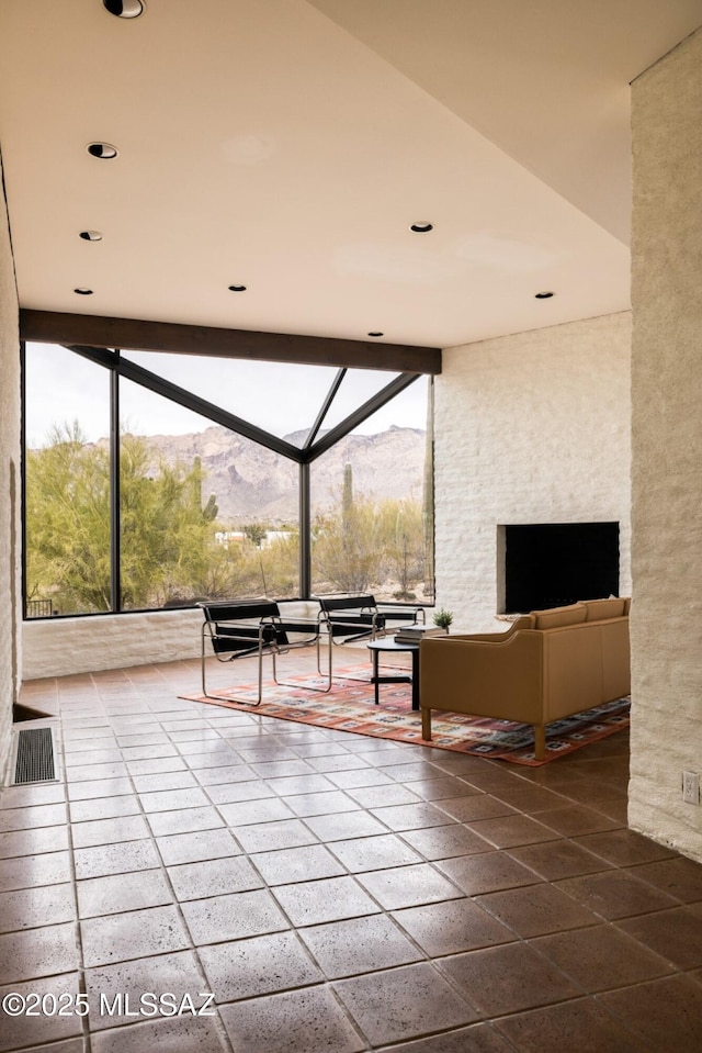 unfurnished living room featuring a sunroom, a wall of windows, and recessed lighting