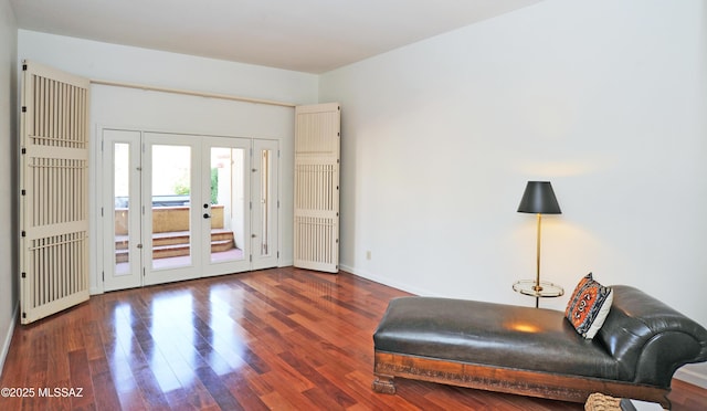 living area featuring french doors, baseboards, and wood finished floors