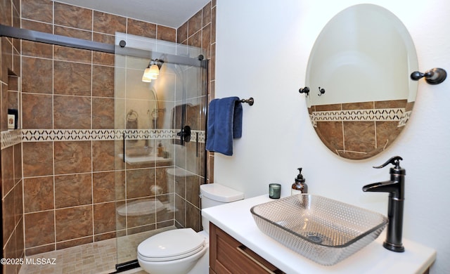 full bathroom with a shower stall, toilet, and vanity