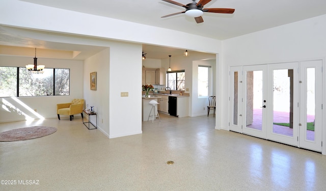 interior space with light speckled floor, french doors, ceiling fan with notable chandelier, and baseboards