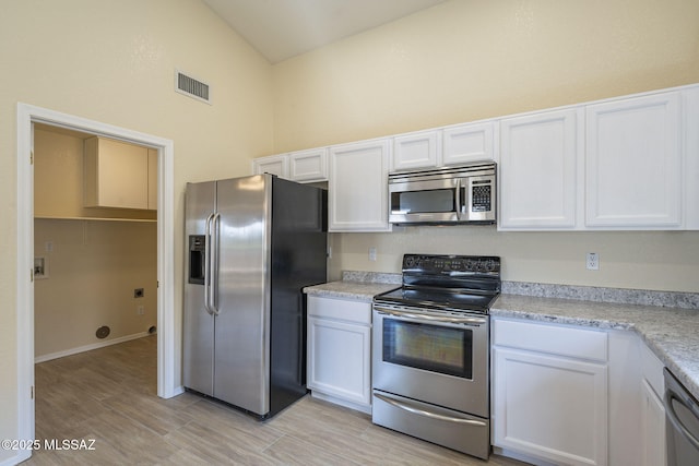 kitchen with stainless steel appliances, light countertops, and white cabinetry