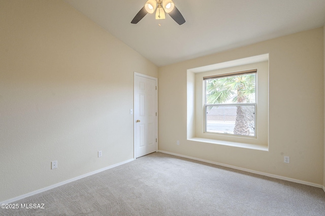 empty room featuring carpet flooring, vaulted ceiling, baseboards, and ceiling fan