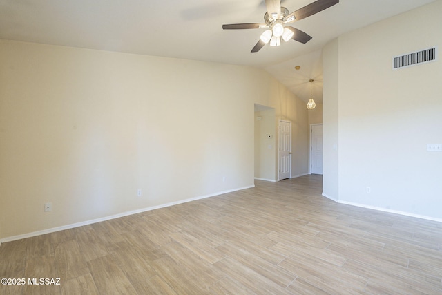 empty room featuring visible vents, baseboards, a ceiling fan, light wood-style flooring, and vaulted ceiling