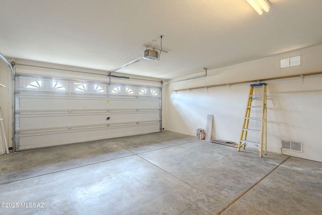 garage featuring visible vents and a garage door opener