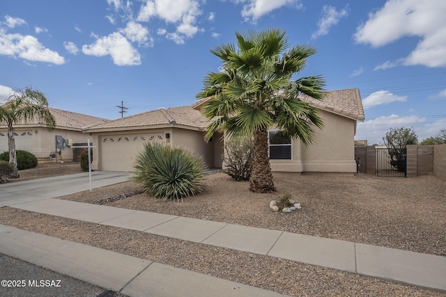 view of front of property featuring a gate, driveway, a tiled roof, and stucco siding