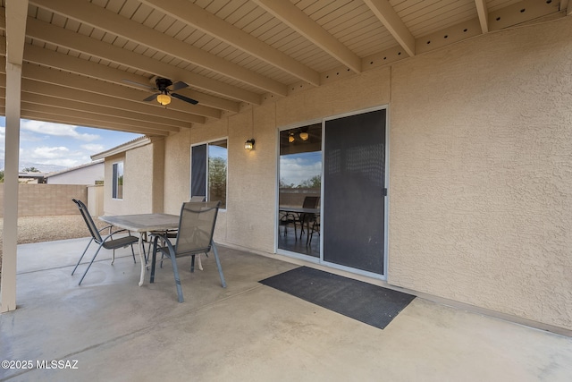 view of patio featuring outdoor dining area, fence, and ceiling fan