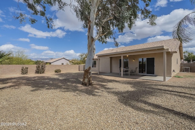 rear view of house featuring a fenced backyard, central air condition unit, a tile roof, stucco siding, and a patio area