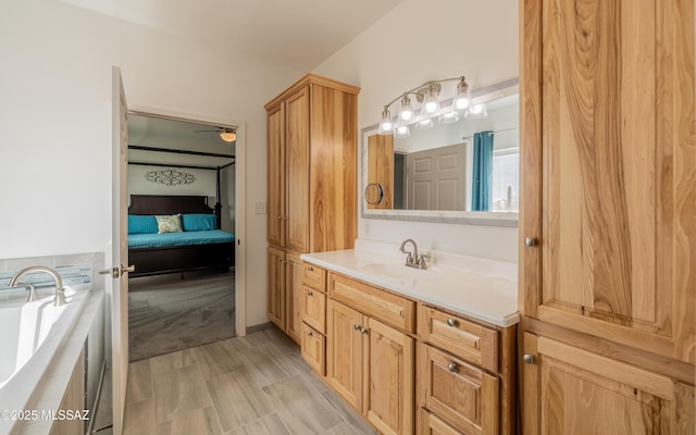 ensuite bathroom with ensuite bathroom, a tub to relax in, and vanity