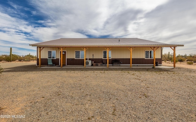 back of house featuring a patio area and metal roof