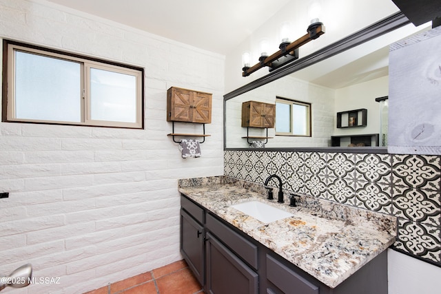 bathroom with tasteful backsplash, a healthy amount of sunlight, vanity, and tile patterned floors