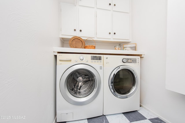 washroom featuring marble finish floor, baseboards, washer and dryer, and cabinet space